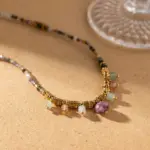 Woman wearing LIVKE multi-color stone necklace at desert festival, showcasing boho jewelry with adjustable gold pendant