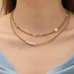 Woman wearing LIVKE pearl and green beaded necklace with silk blouse, showcasing minimalist jewelry for work and evening events