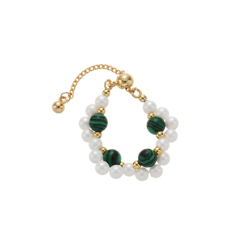 Hand wearing LIVKE adjustable wrap ring with pearls and green aventurine, layered with slim bands for boho chic style