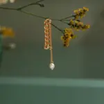 Model turning head to showcase flowing pearl tassels catching sunlight