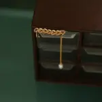 Model turning head to showcase flowing pearl tassels catching sunlight