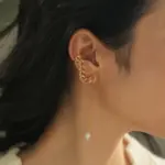 Model turning head to showcase flowing pearl tassels catching sunlight