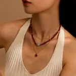 LIVKE’s 18K gold-plated red agate necklace layered with delicate chains on a linen backdrop, styled for boho-chic elegance