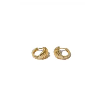 Contemporary art gallery visitor wearing LIVKE gold spiral ear cuffs with minimalist outfit, showcasing architectural jewelry styling