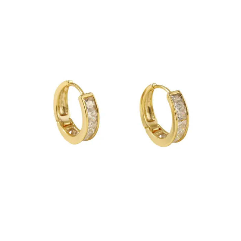 Gold ear cuff with square CZ stones on model's ear catching sunlight