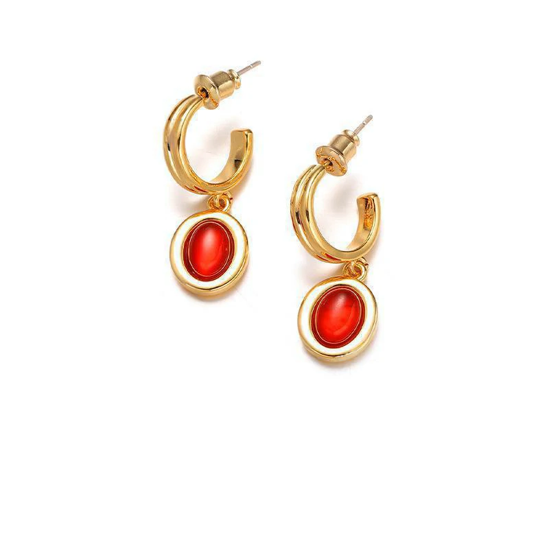Layered 18K gold-plated tiger eye earrings with red/black/brown stone pendants on terrazzo backdrop, styled with leather cord necklaces