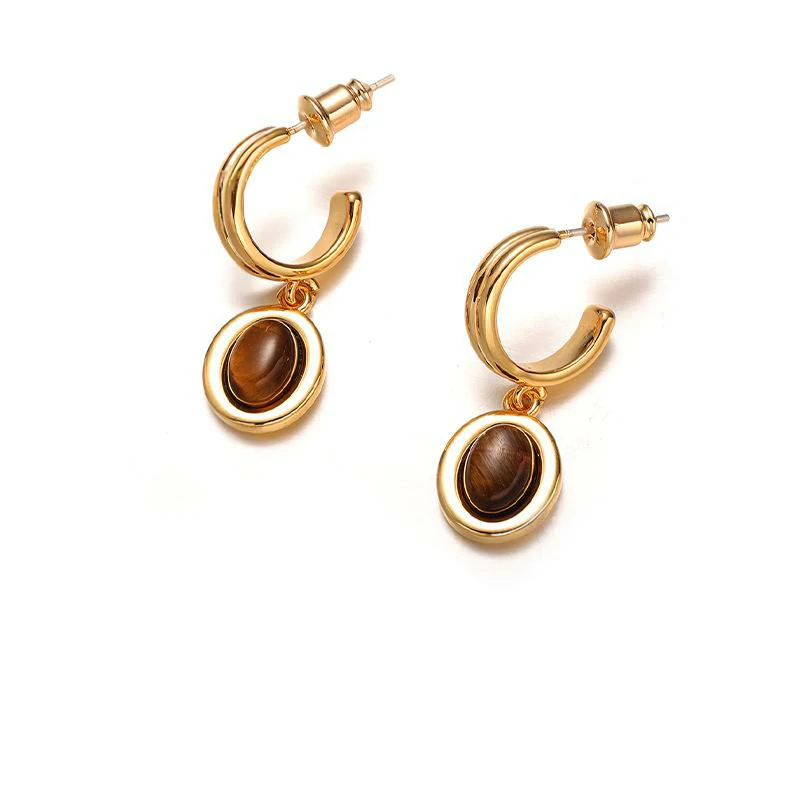 Layered 18K gold-plated tiger eye earrings with red/black/brown stone pendants on terrazzo backdrop, styled with leather cord necklaces