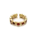 Hand wearing LIVKE red agate titanium ring with textured gold band in boardroom setting, showcasing power jewelry for professionals