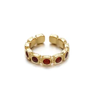 Hand wearing LIVKE red agate titanium ring with textured gold band in boardroom setting, showcasing power jewelry for professionals