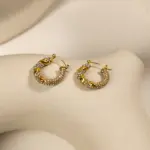 Gold twisted hoop earrings catching sunlight with layered necklaces on tanned skin