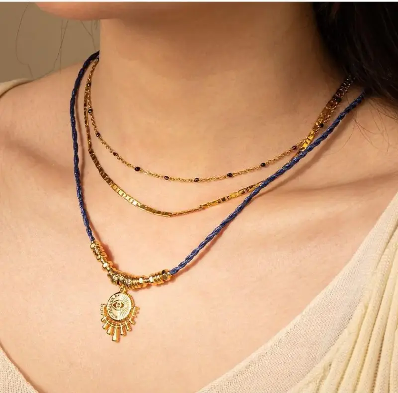 LIVKE’s gold-plated brass necklace featuring a lapis lazuli pendant, styled with a white linen blouse for effortless elegance.