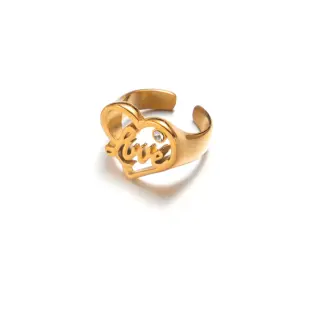 Woman wearing LIVKE gold love signet ring while holding cappuccino in Parisian café, showcasing stackable jewelry styling