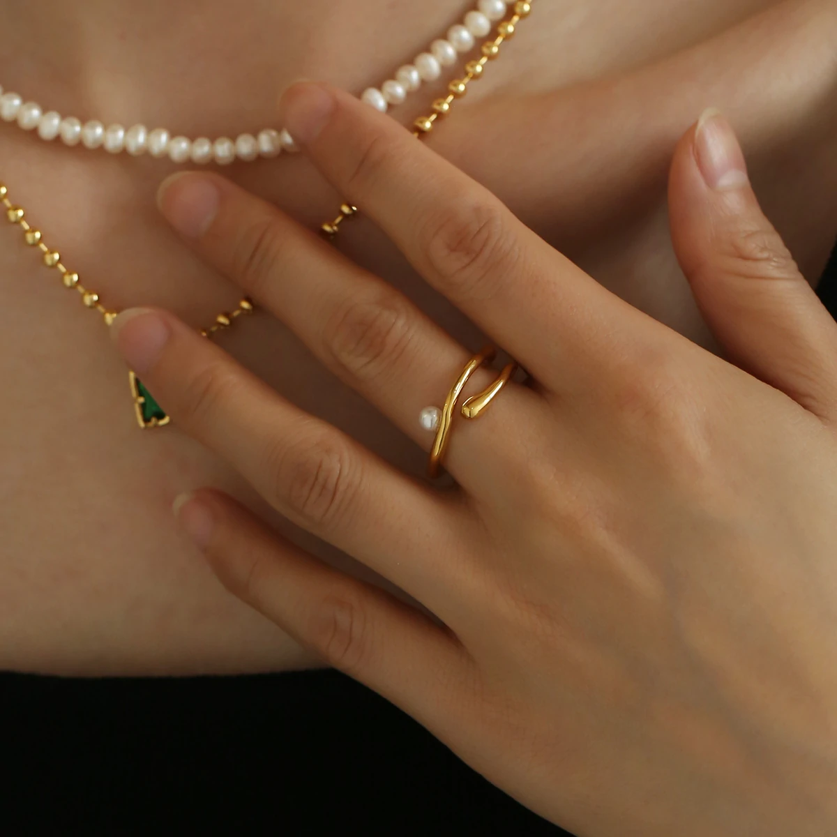 livke-wave-band-pearl-ring-adjusting (2) Hand model adjusting open wave ring with pearl under golden hour sunlight