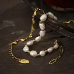 18K gold plated chain bracelet with twelve engraved heart charms, blending Edwardian elegance with modern minimalist jewelry trends